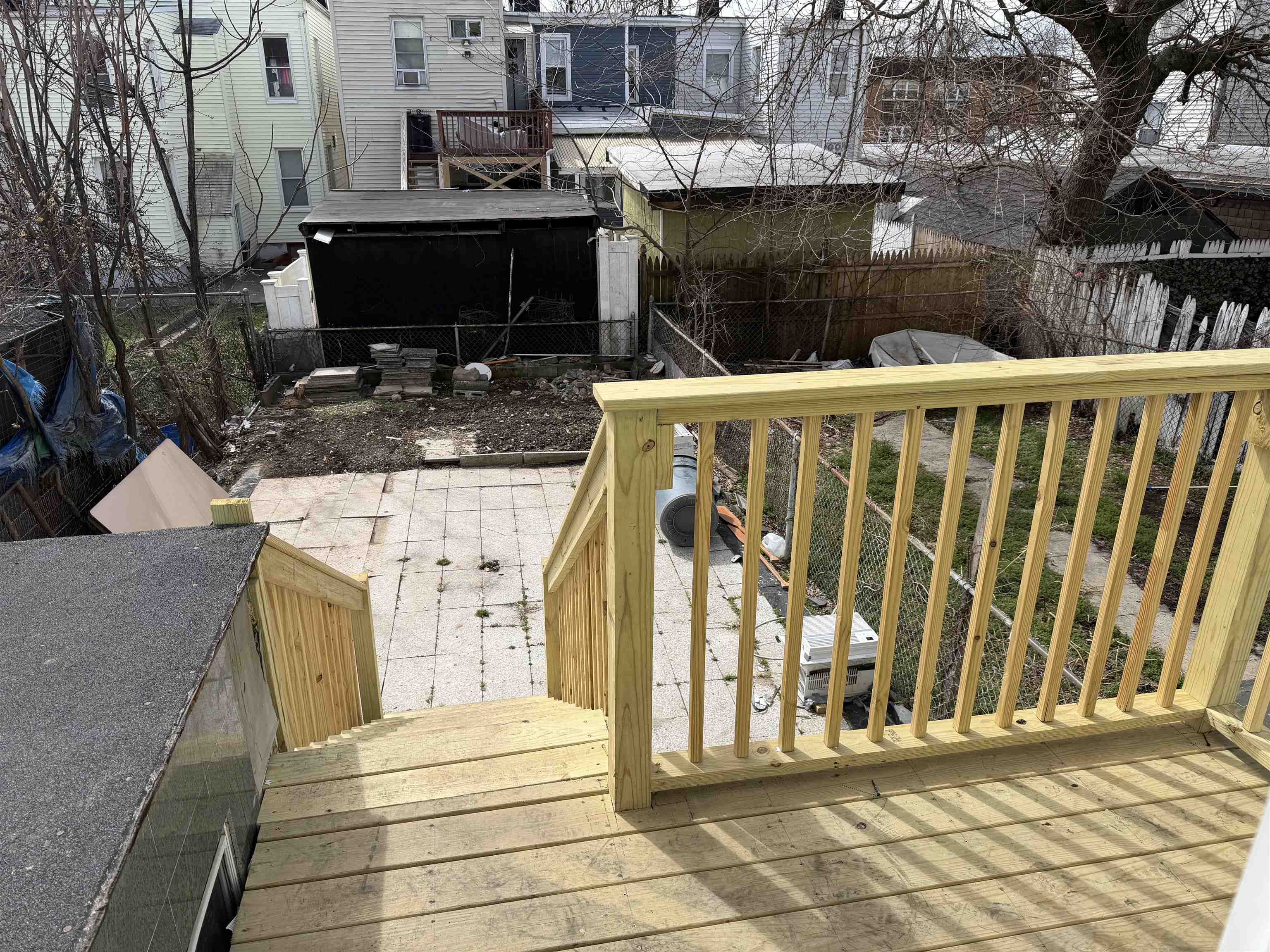 419 4th Street, Unit 1 Union City, NJ 07087 - Photo 19 of 20 a view of a patio with table and chairs with wooden floor and fence