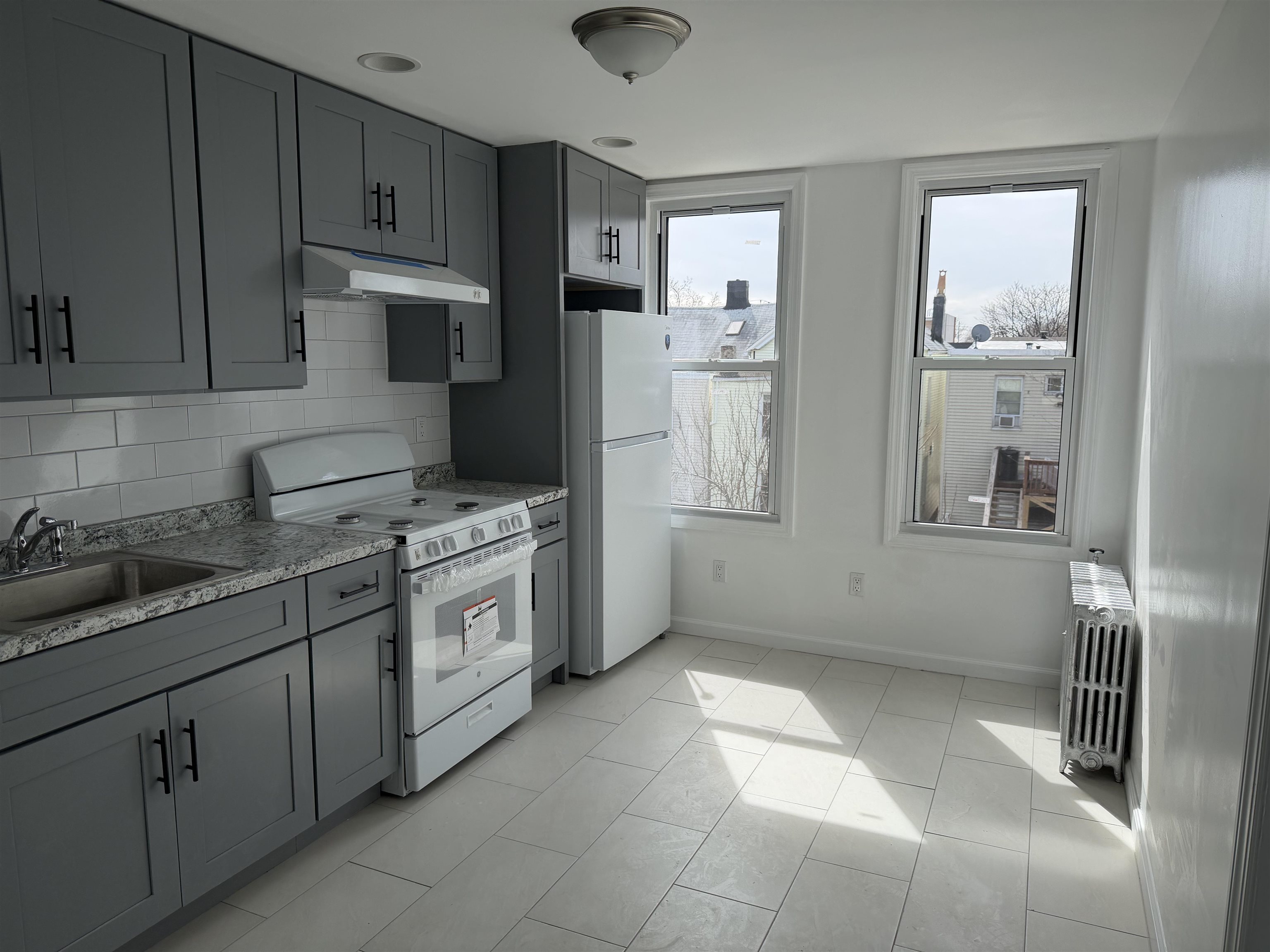 419 4th Street, Unit 1 Union City, NJ 07087 - Photo 5 of 20 a kitchen with a stove a sink and a refrigerator