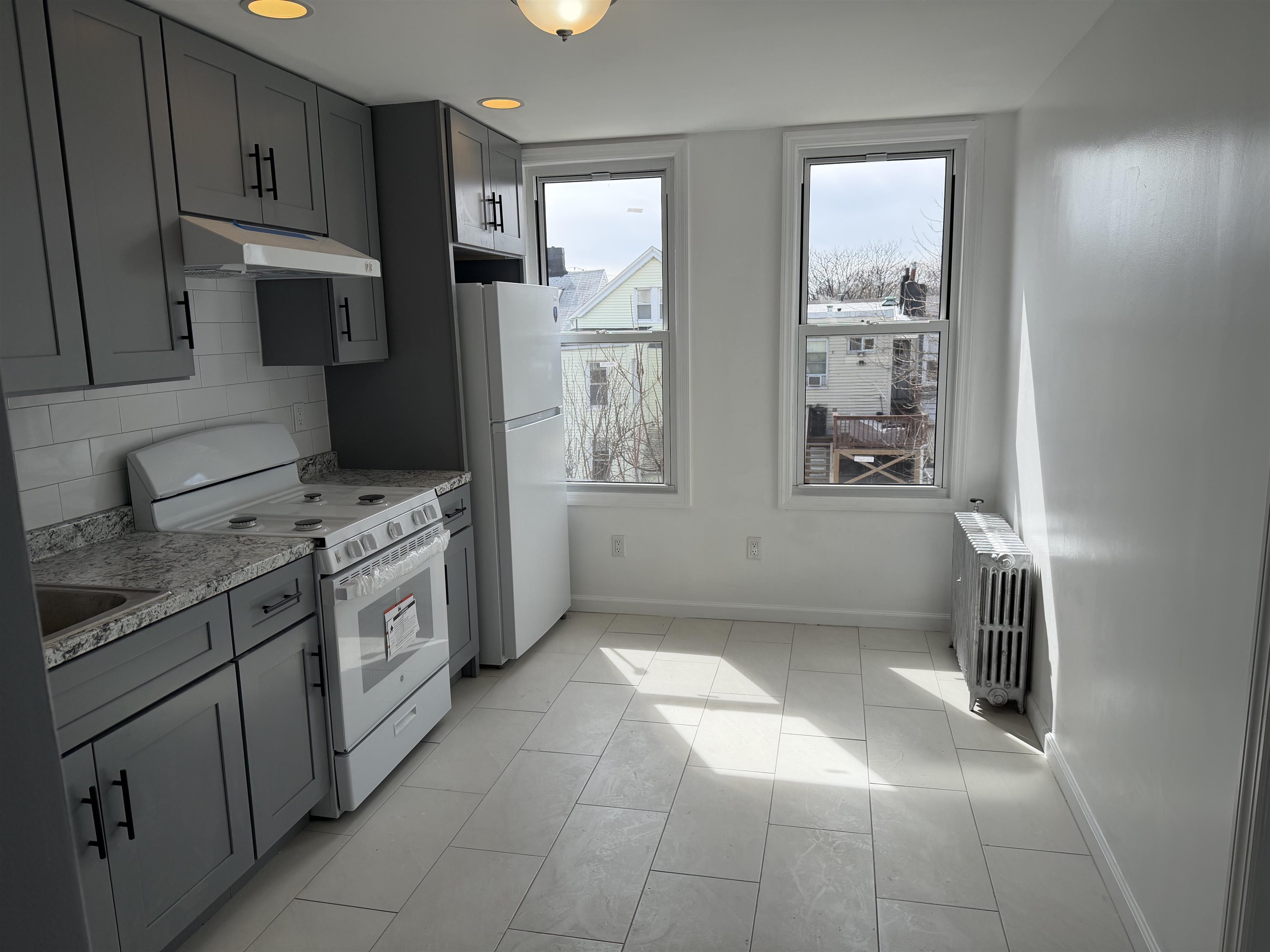 419 4th Street, Unit 1 Union City, NJ 07087 - Photo 10 of 20 a kitchen with stainless steel appliances granite countertop a stove a refrigerator and a cabinets