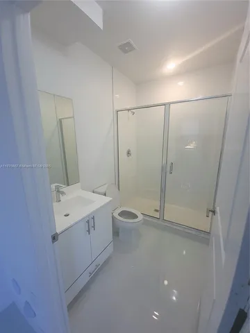 a bathroom with a granite countertop sink a toilet and shower