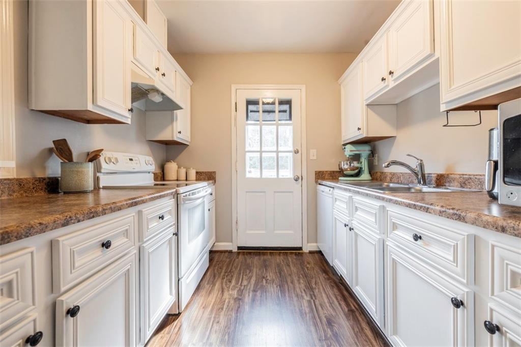 a kitchen with granite countertop a sink cabinets stainless steel appliances and a counter space