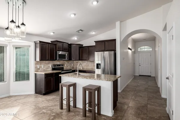 a kitchen with stainless steel appliances granite countertop a refrigerator and a stove top oven
