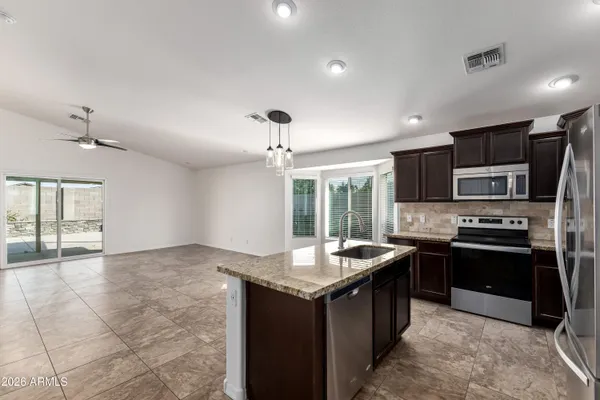 a kitchen with stainless steel appliances granite countertop a sink stove and refrigerator