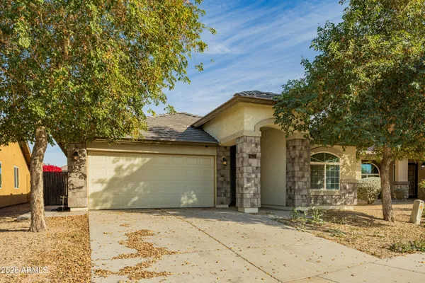 a front view of a house with a tree