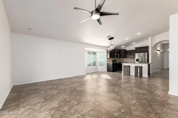 a view of kitchen with kitchen island refrigerator stove and white cabinets