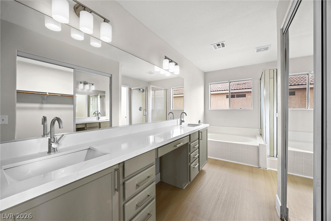 2650 Whisper Ridge Street Las Vegas, NV 89156 - Photo 16 of 28 A long stone counter vanity anchors this bathroom featuring a soaking tub and walk-in shower.