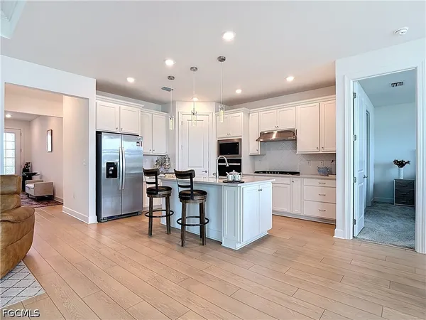 a kitchen with stainless steel appliances kitchen island granite countertop a refrigerator and a stove top oven
