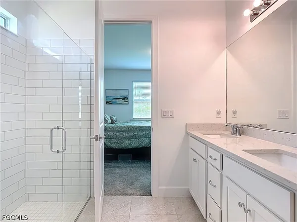 a en suite bathroom with a granite countertop sink and a mirror