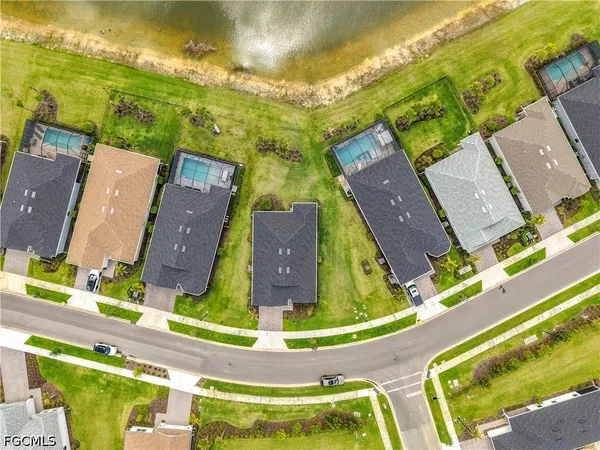 an aerial view of residential houses with outdoor space and swimming pool