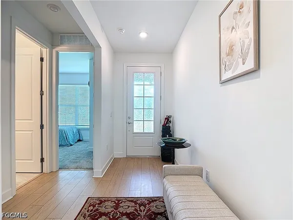 a view of a hallway with wooden floor and furniture
