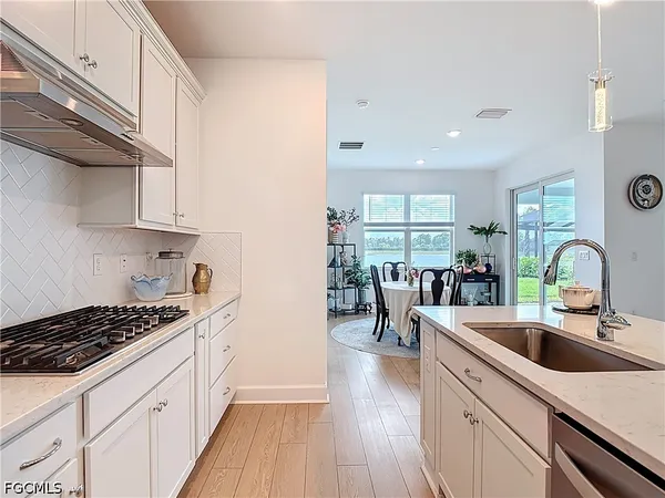 a kitchen with sink a stove and cabinets