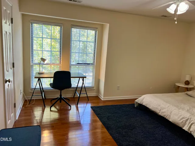 a bedroom with a bed window and wooden floor