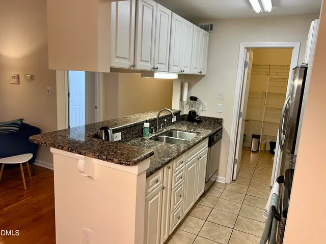 a kitchen with stainless steel appliances granite countertop a sink a stove and a refrigerator with granite countertops