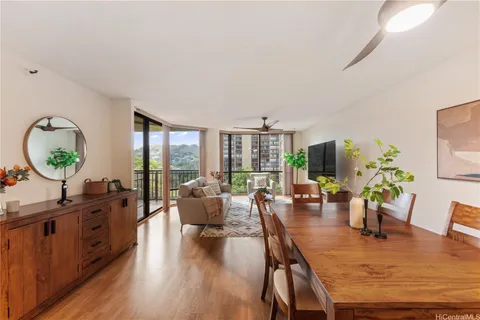 a living room with furniture potted plant wooden floor and a large window
