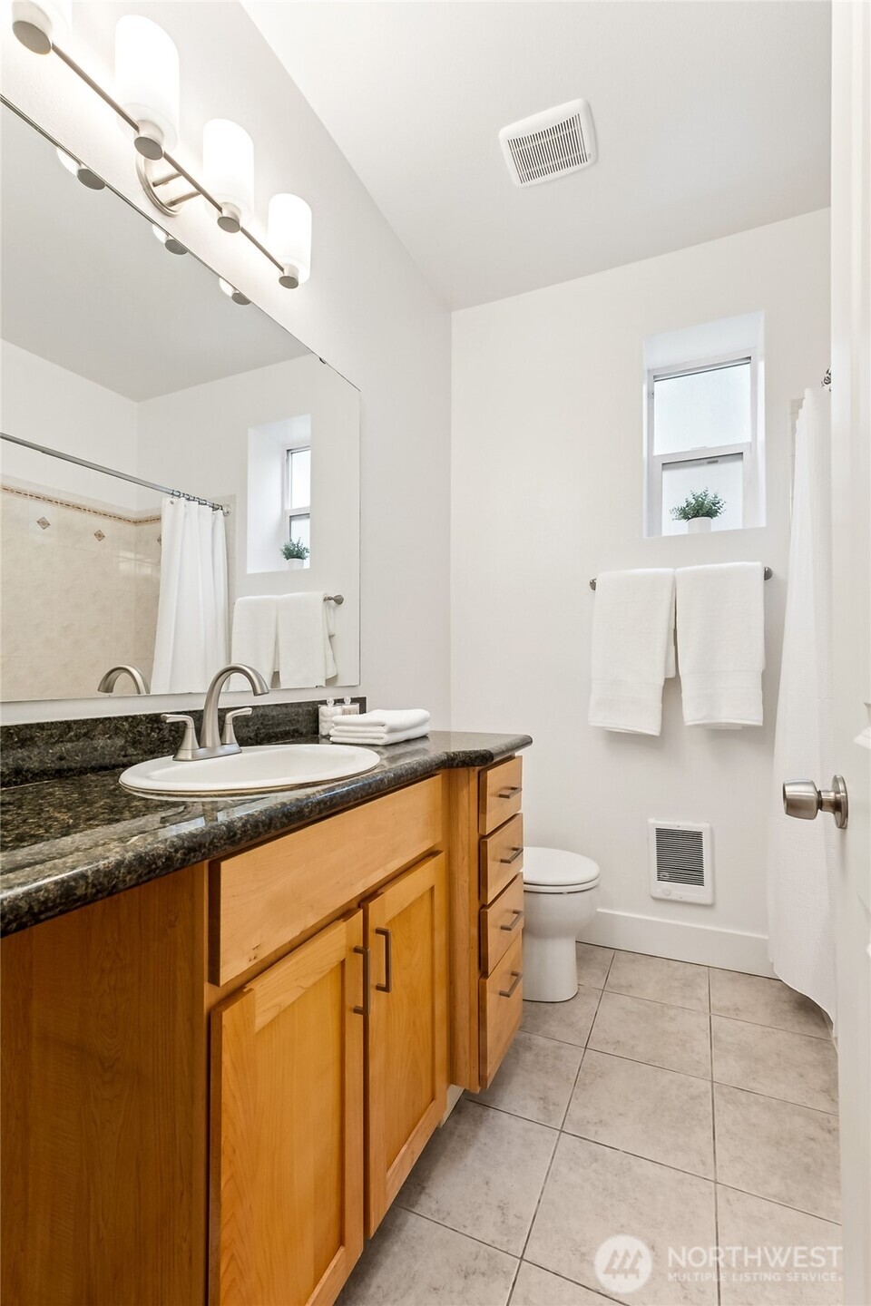 5907 40th Avenue Southwest, Unit B Seattle, WA 98136 - Photo 12 of 23 a spacious bathroom with a granite countertop sink a toilet and a mirror