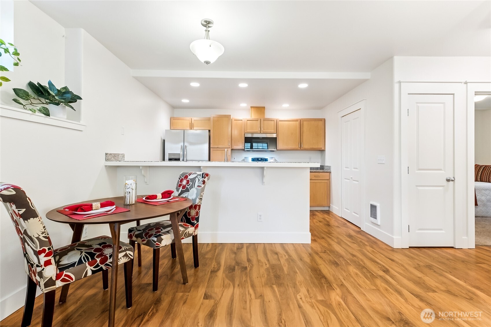5907 40th Avenue Southwest, Unit B Seattle, WA 98136 - Photo 5 of 23 a kitchen with stainless steel appliances kitchen island granite countertop a dining table chairs and white cabinets