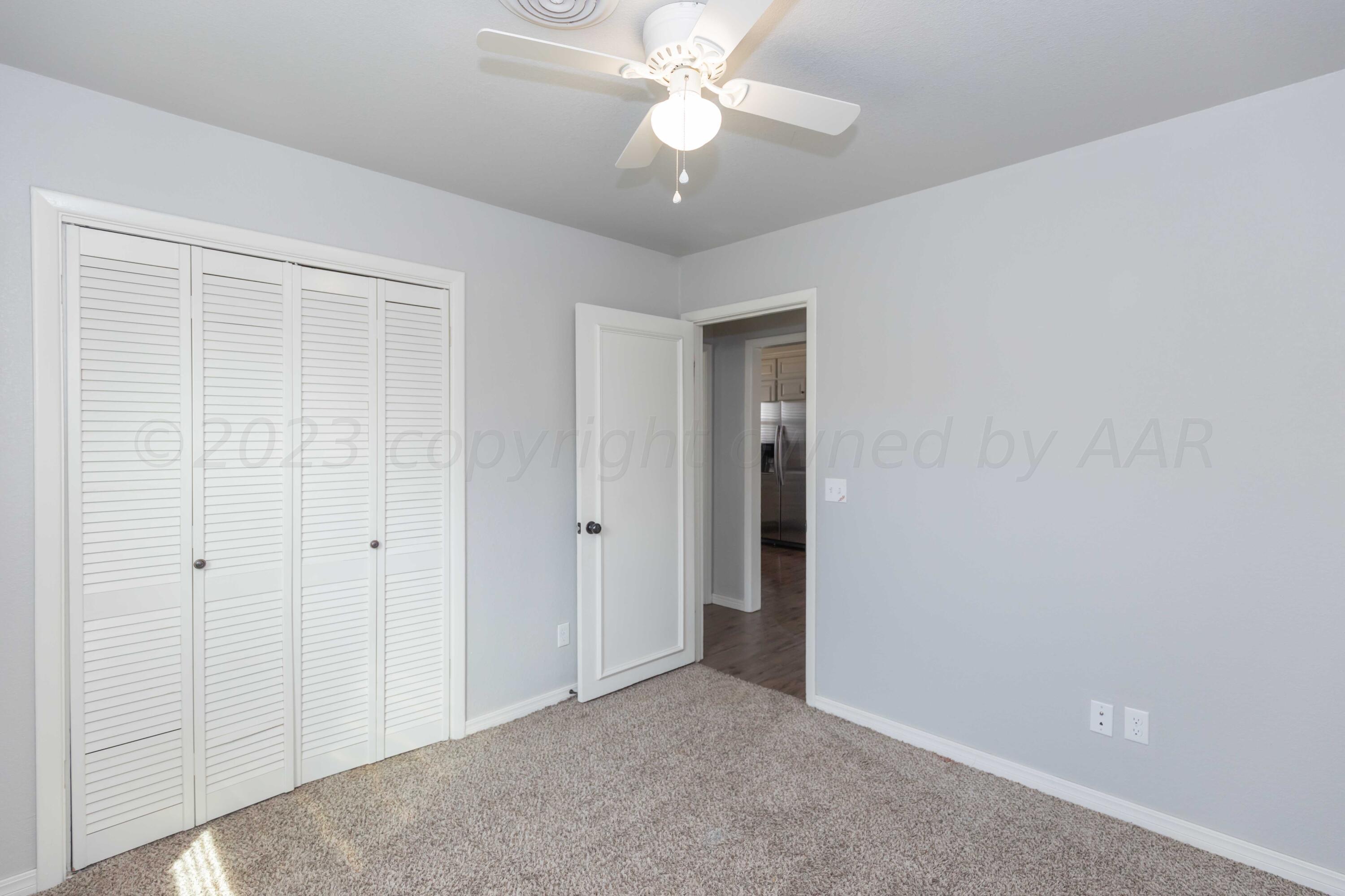 5201 South Austin Street Amarillo, TX 79110 - Photo 28 of 40 an empty room with closet and a chandelier fan