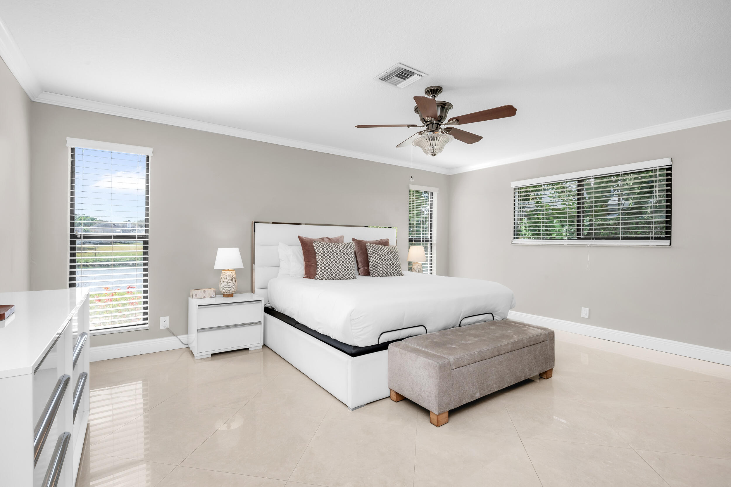 3250 Lakeview Boulevard Delray Beach, FL 33445 - Photo 12 of 26 a bedroom with a large bed and a chandelier fan