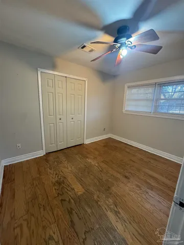 a view of an empty room with a chandelier fan