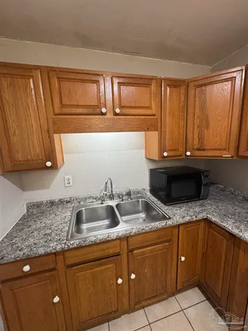 a kitchen with granite countertop stainless steel appliances a sink dishwasher stove and cabinets