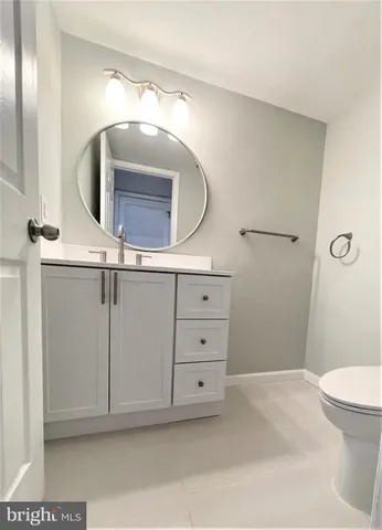 a bathroom with a sink a mirror a toilet and vanity