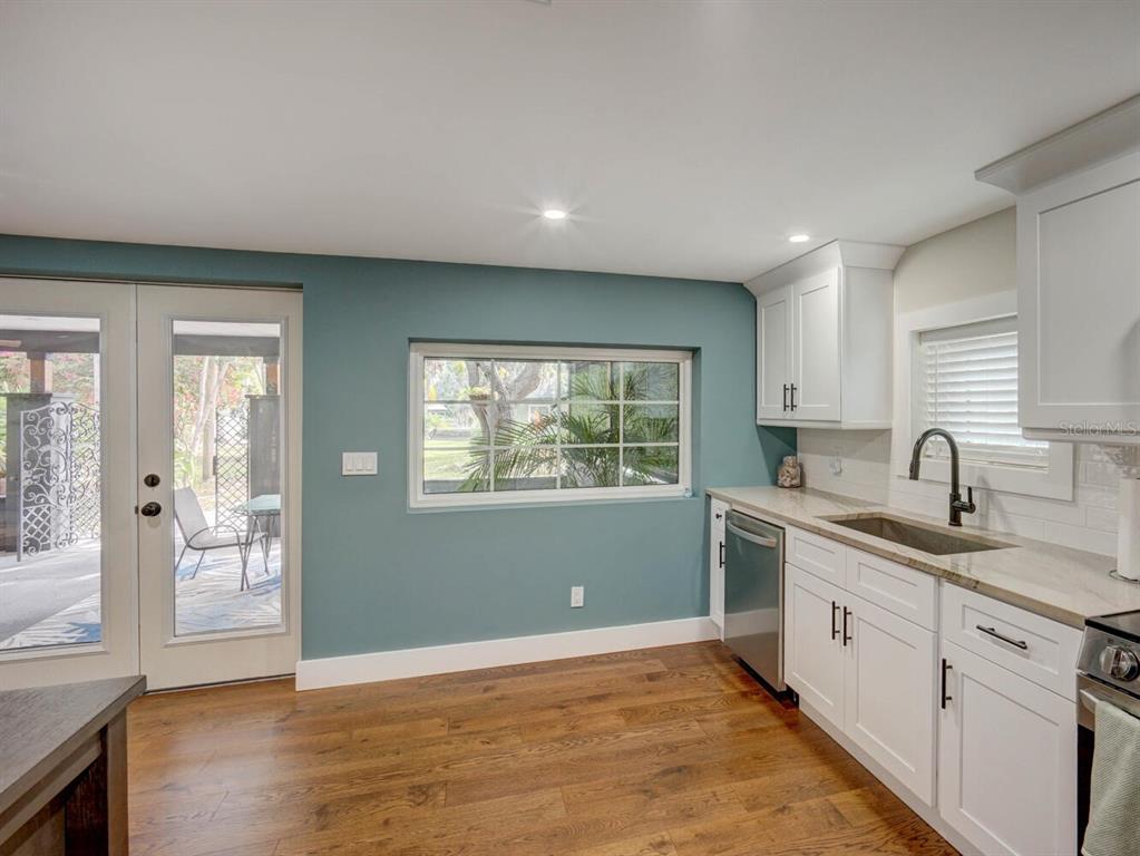 6746 River Road New Port Richey, FL 34652 - Photo 18 of 55 a view of a kitchen with a sink dishwasher and wooden floor