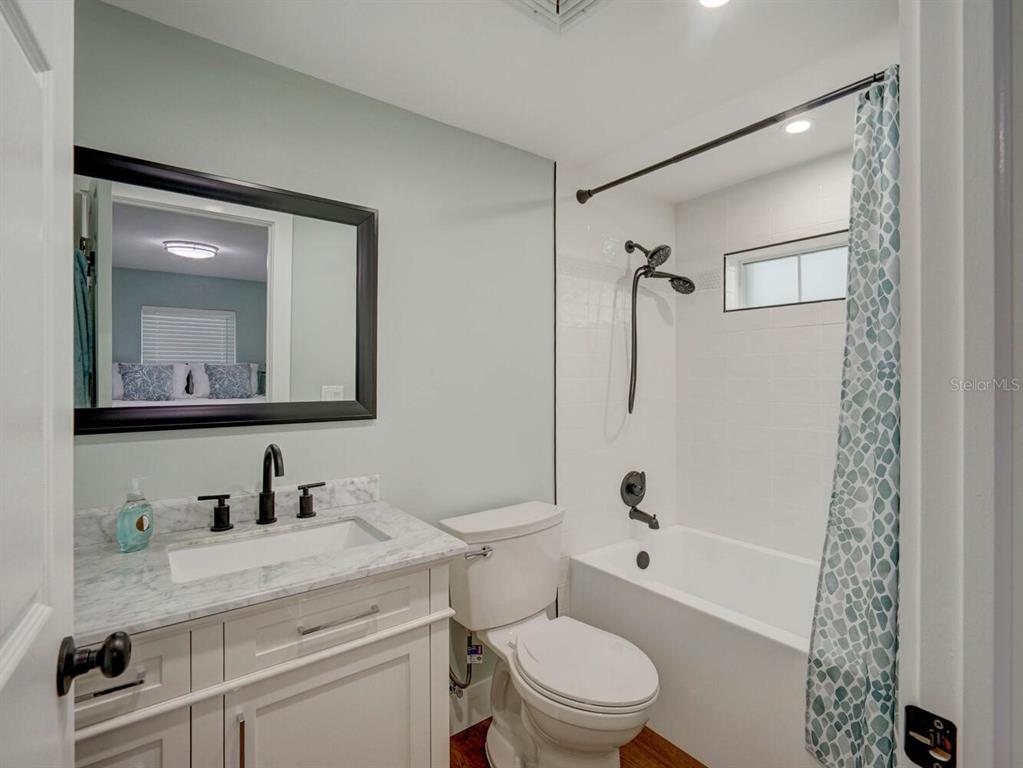 6746 River Road New Port Richey, FL 34652 - Photo 22 of 55 a bathroom with a granite countertop sink toilet a mirror a vanity and shower
