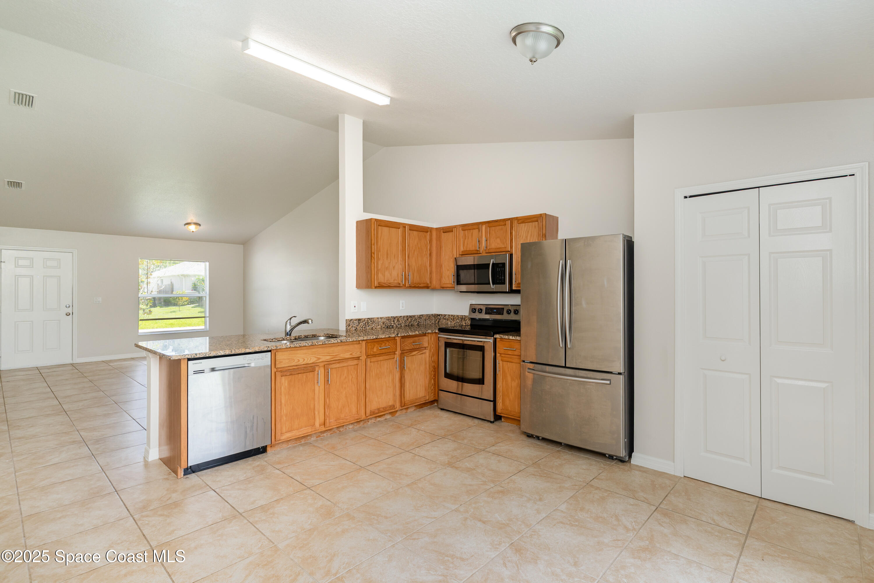 774 Fletcher Road Southeast Palm Bay, FL 32909 - Photo 6 of 20 a kitchen with stainless steel appliances a refrigerator and a stove top oven