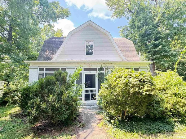 a front view of house with trees in the background