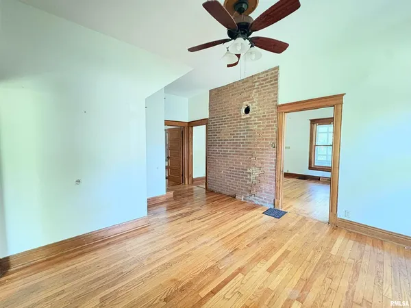 a view of an empty room with wooden floor