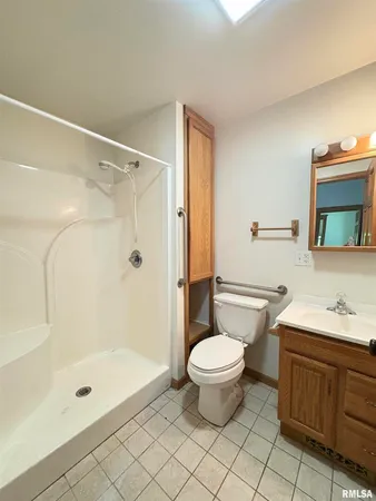 a bathroom with a granite countertop sink a toilet and shower