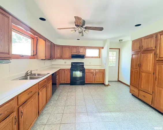 a kitchen with stainless steel appliances granite countertop a refrigerator oven a sink dishwasher and white cabinets with wooden floor