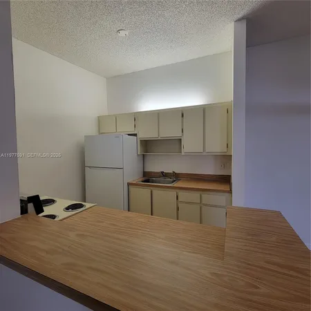 a kitchen with a stove cabinets and wooden floor