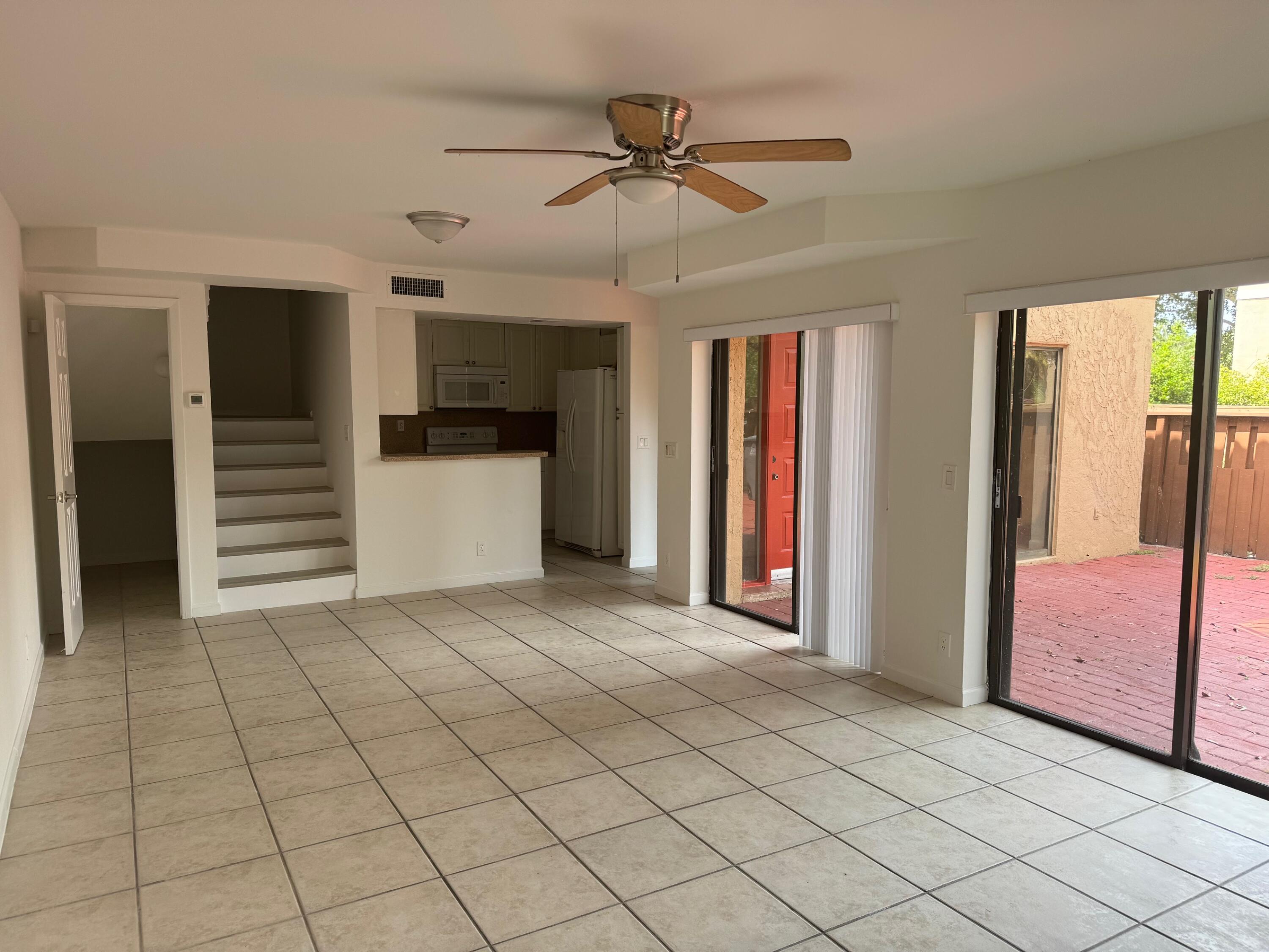 8068 Severn Drive, Unit B Boca Raton, FL 33433 - Photo 12 of 12 a view of a livingroom with a staircase and a ceiling fan