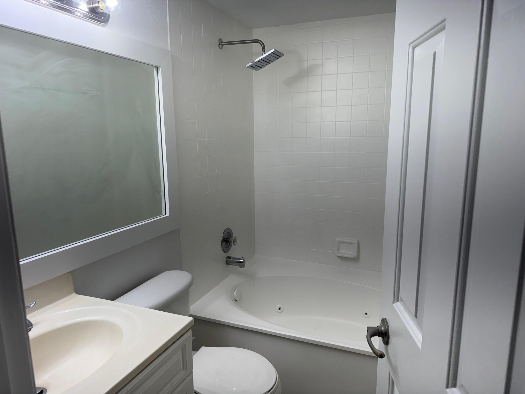 8068 Severn Drive, Unit B Boca Raton, FL 33433 - Photo 5 of 12 a bathroom with a sink toilet and shower