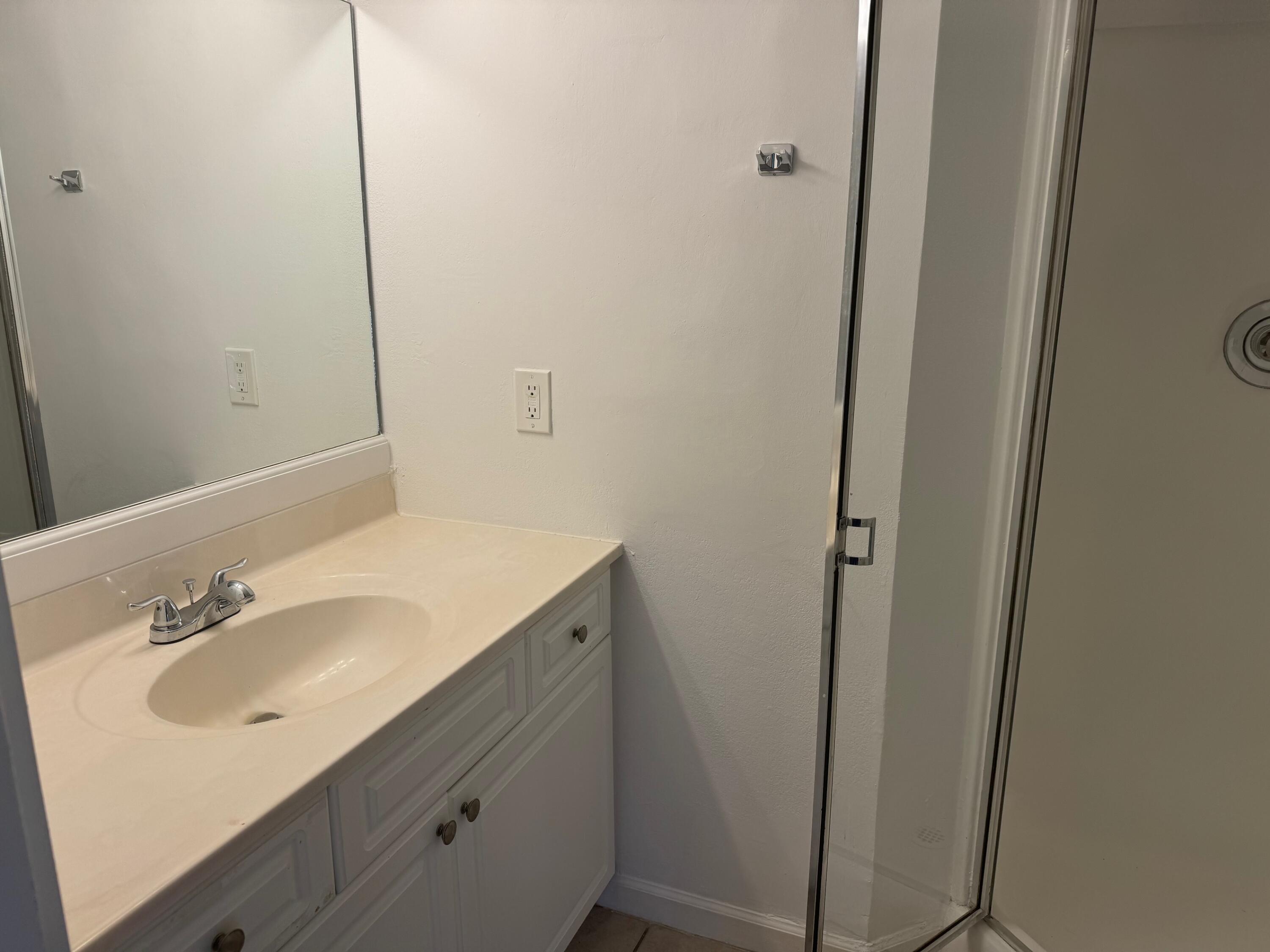8068 Severn Drive, Unit B Boca Raton, FL 33433 - Photo 8 of 12 a bathroom with a sink and mirror