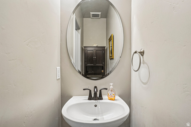 203 North 1900th Street West Mapleton, UT 84664 - Photo 35 of 48 Pedestal sink with dark bronze faucet, oval wall mirror, and brushed nickel towel ring