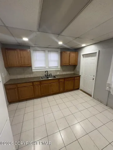 a kitchen with stainless steel appliances a sink a stove a microwave a counter top space and cabinets