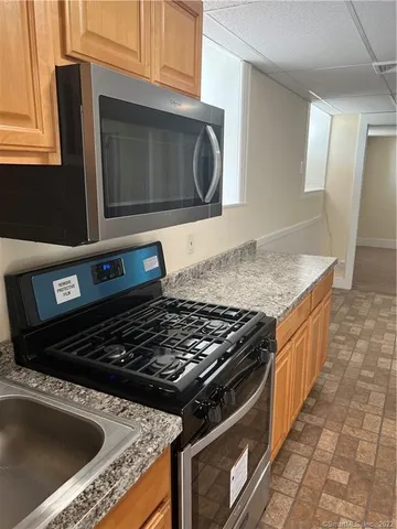 a kitchen with granite countertop a sink and a stove top oven