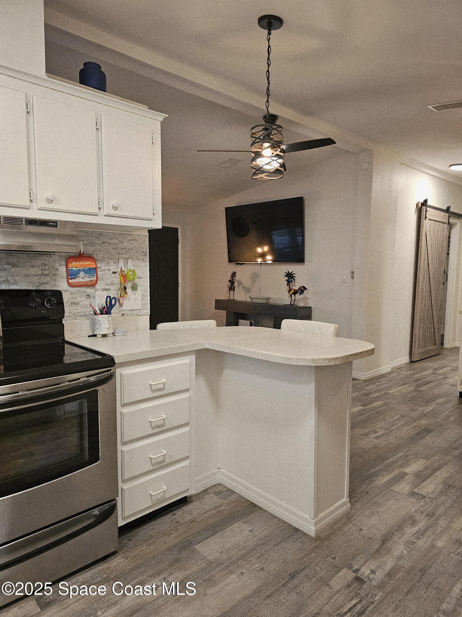 1809 Mango Street Northeast Palm Bay, FL 32905 - Photo 11 of 35 a kitchen with stainless steel appliances a white stove top oven and cabinets