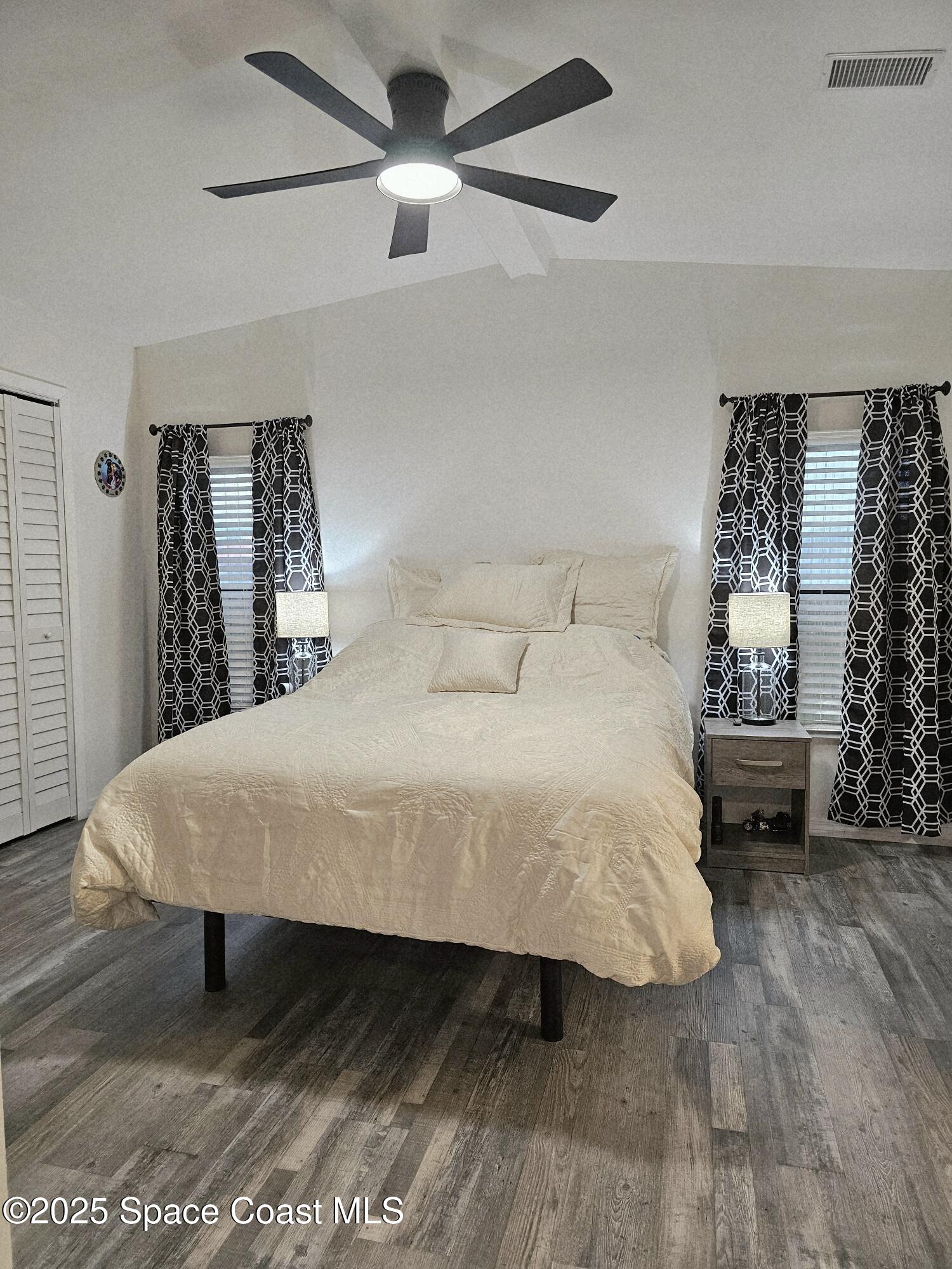 1809 Mango Street Northeast Palm Bay, FL 32905 - Photo 21 of 35 a large bed sitting in a bedroom and chandelier next to a window