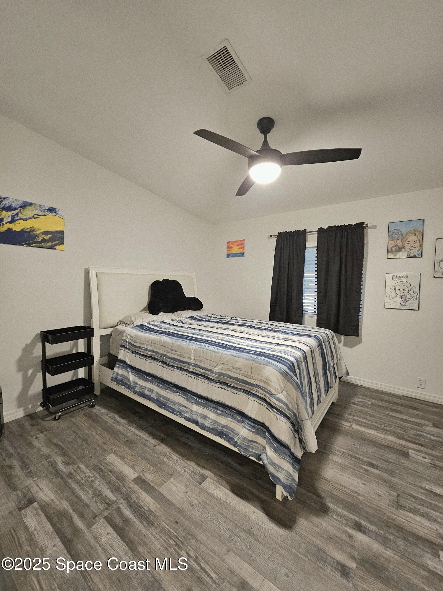 1809 Mango Street Northeast Palm Bay, FL 32905 - Photo 32 of 35 a bedroom with a bed and a chandelier