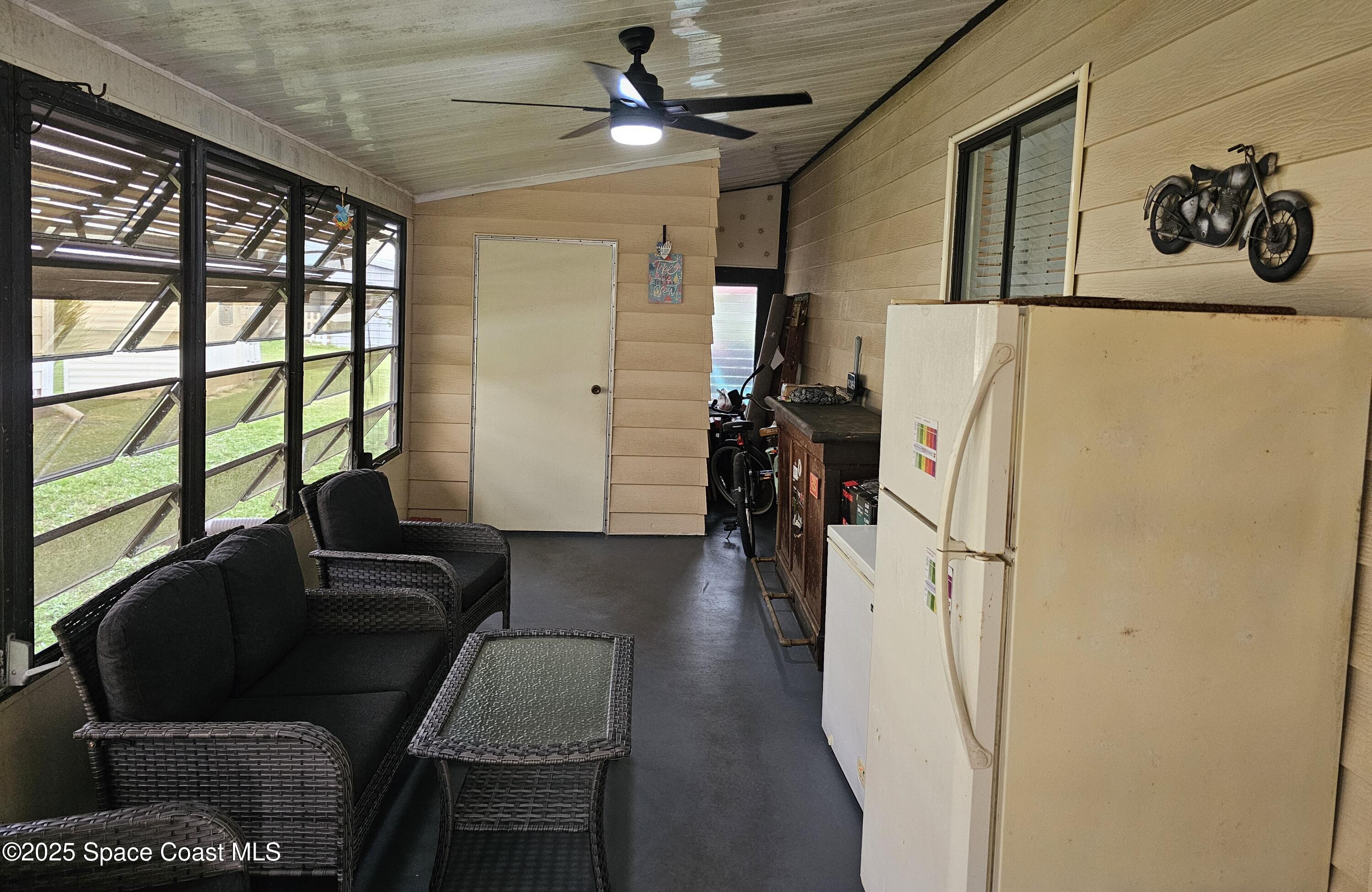 1809 Mango Street Northeast Palm Bay, FL 32905 - Photo 34 of 35 a hallway with a couch and a large window with wooden floor