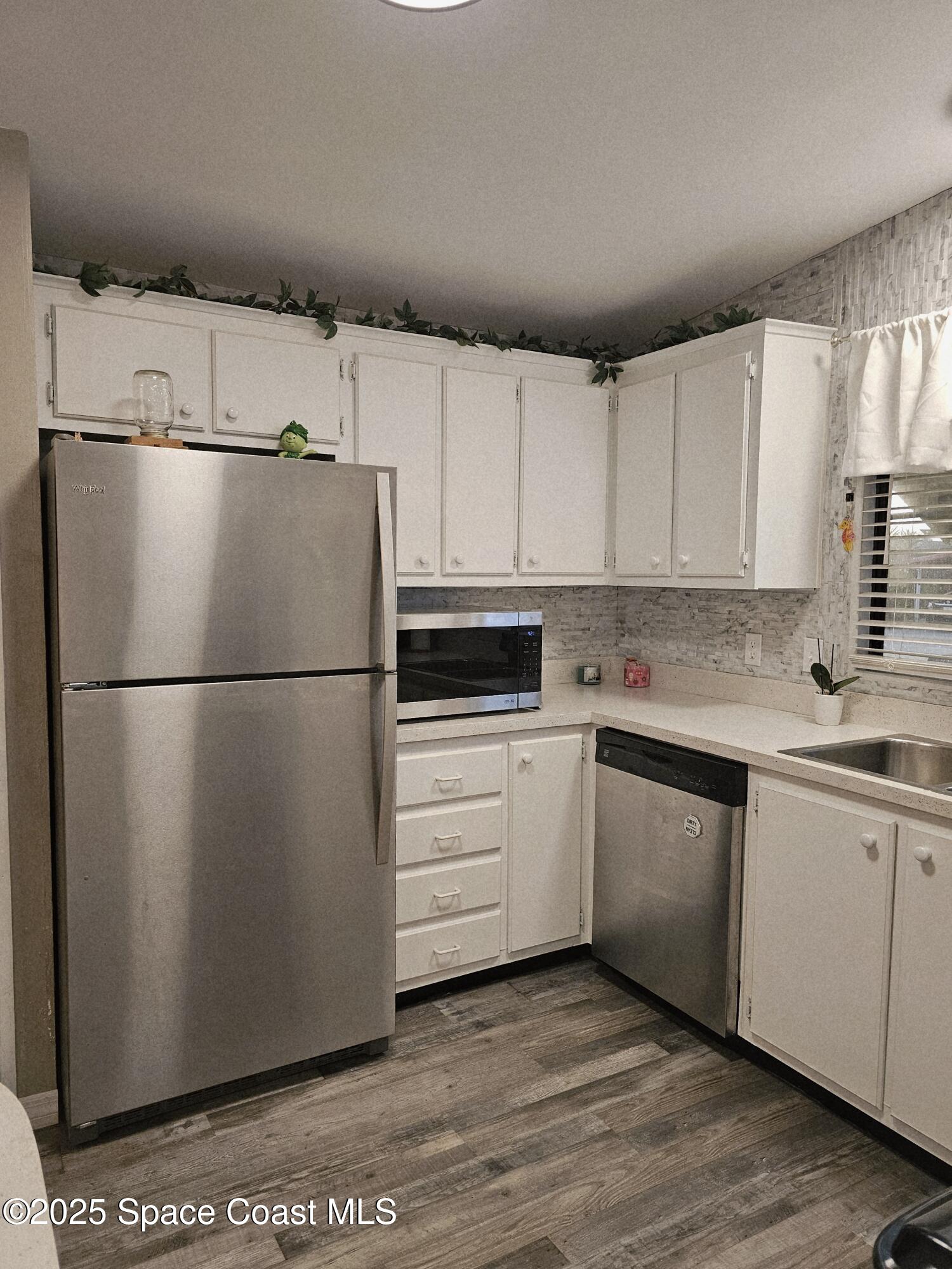 1809 Mango Street Northeast Palm Bay, FL 32905 - Photo 7 of 35 a kitchen with appliances cabinets and a sink