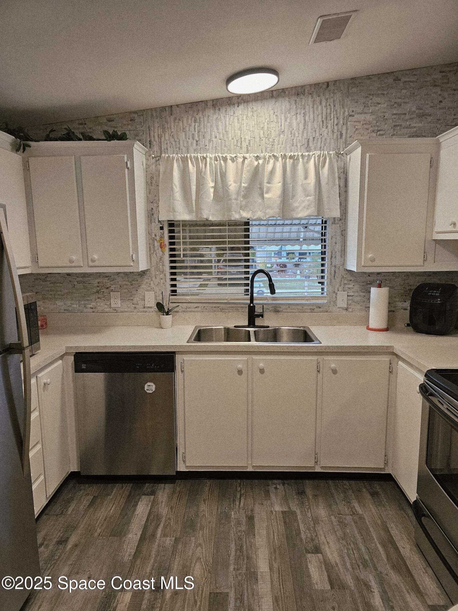 1809 Mango Street Northeast Palm Bay, FL 32905 - Photo 8 of 35 a kitchen with a sink cabinets and stainless steel appliances