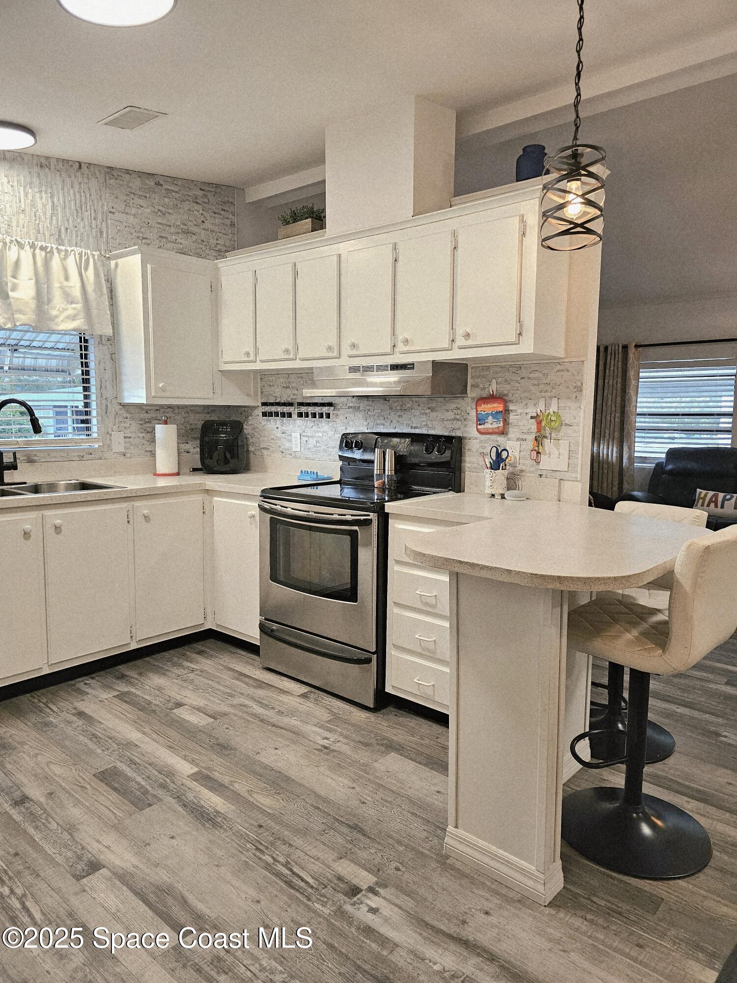 1809 Mango Street Northeast Palm Bay, FL 32905 - Photo 9 of 35 a kitchen with cabinets a sink and appliances