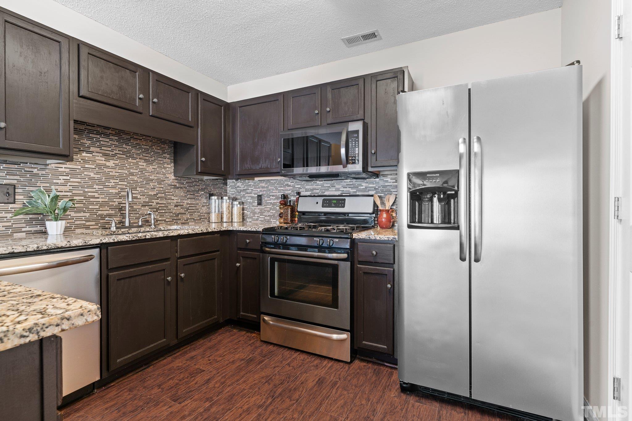 9136 Colony Village Lane Raleigh, NC 27617 - Photo 3 of 17 a kitchen with stainless steel appliances granite countertop a refrigerator stove and sink