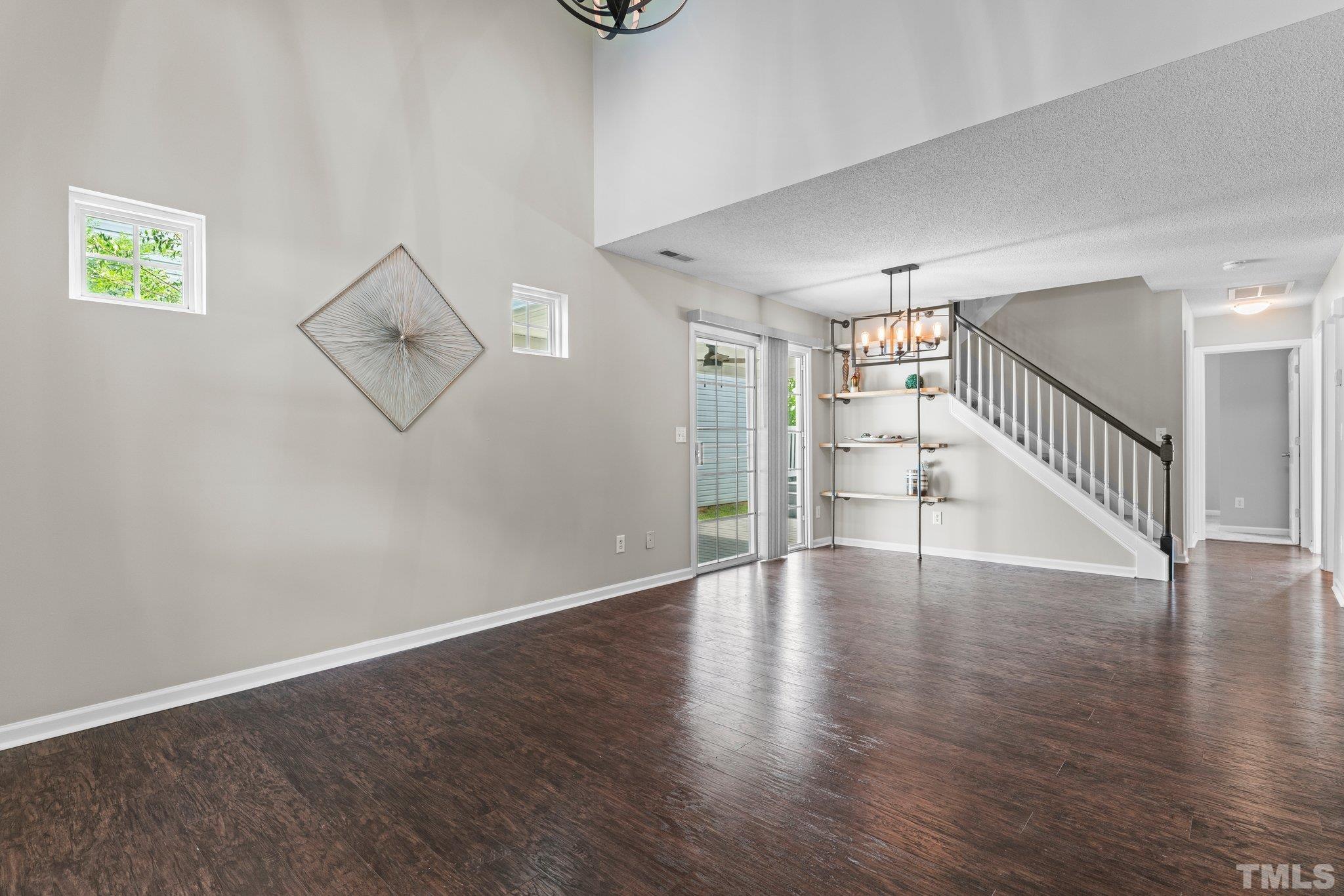 9136 Colony Village Lane Raleigh, NC 27617 - Photo 5 of 17 a view of an empty room with wooden floor and stairs