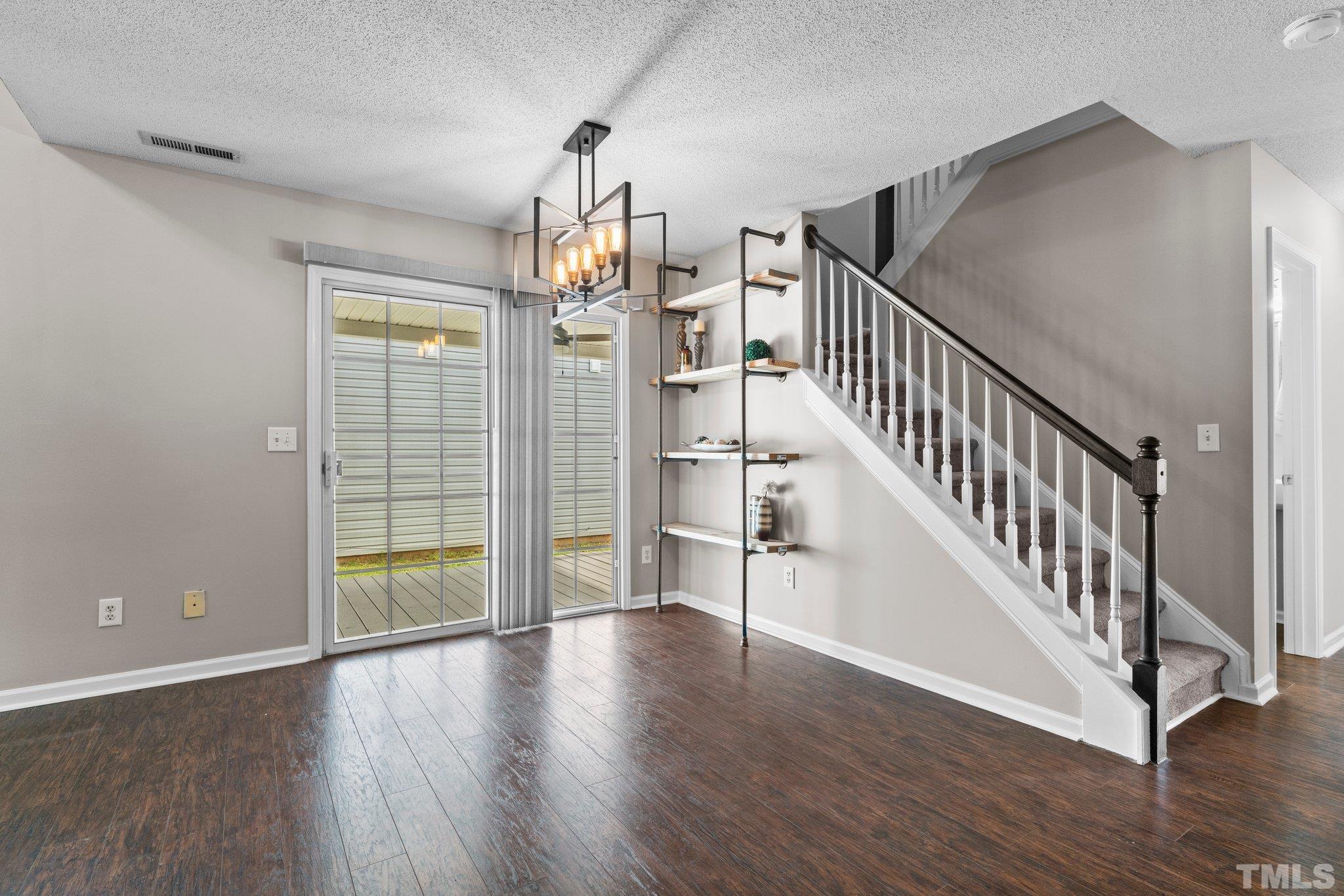 9136 Colony Village Lane Raleigh, NC 27617 - Photo 6 of 17 an empty room with wooden floor and staircase