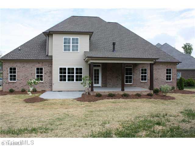 8906 West Pepper Court Oak Ridge, NC 27310 - Photo 2 of 16 Exterior Back. The rear of the home features a private covered porch that steps down to a patio. The entire yard is irrigated. Notice the landscaping on the rear of the home.